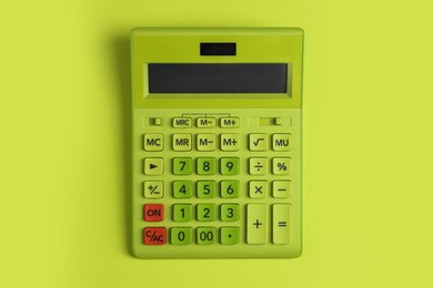 Photo of Modern calculator on green background, top view