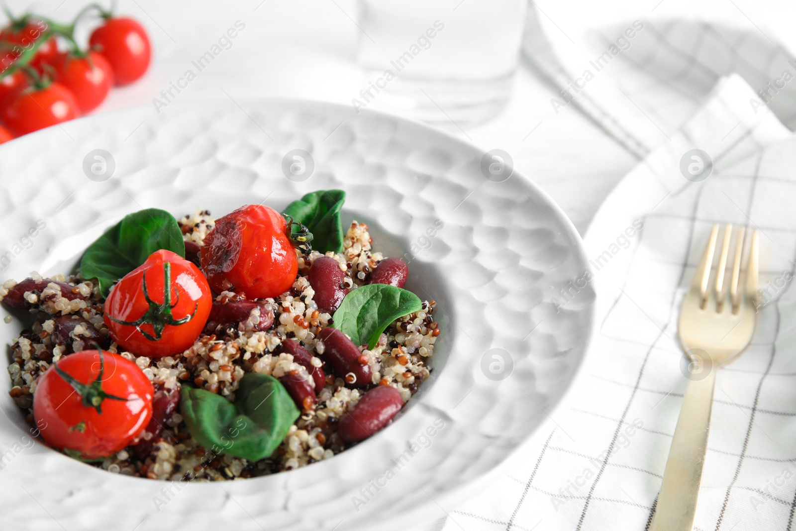 Photo of Plate with healthy quinoa salad and vegetables on table, closeup