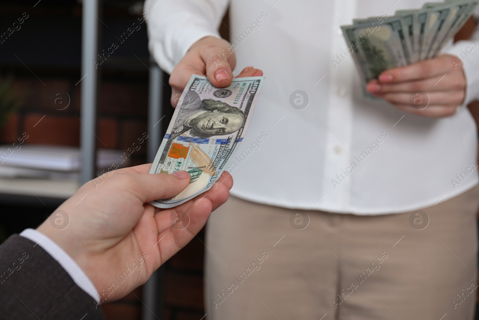 Photo of Woman giving money to man indoors, closeup. Currency exchange