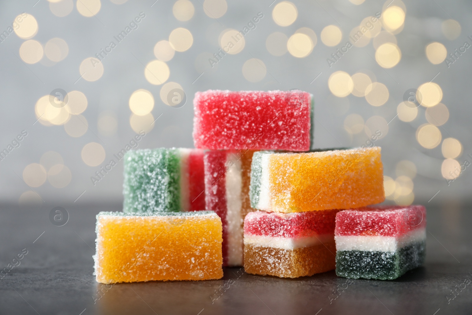 Photo of Pile of fruit jelly candies on grey table, closeup