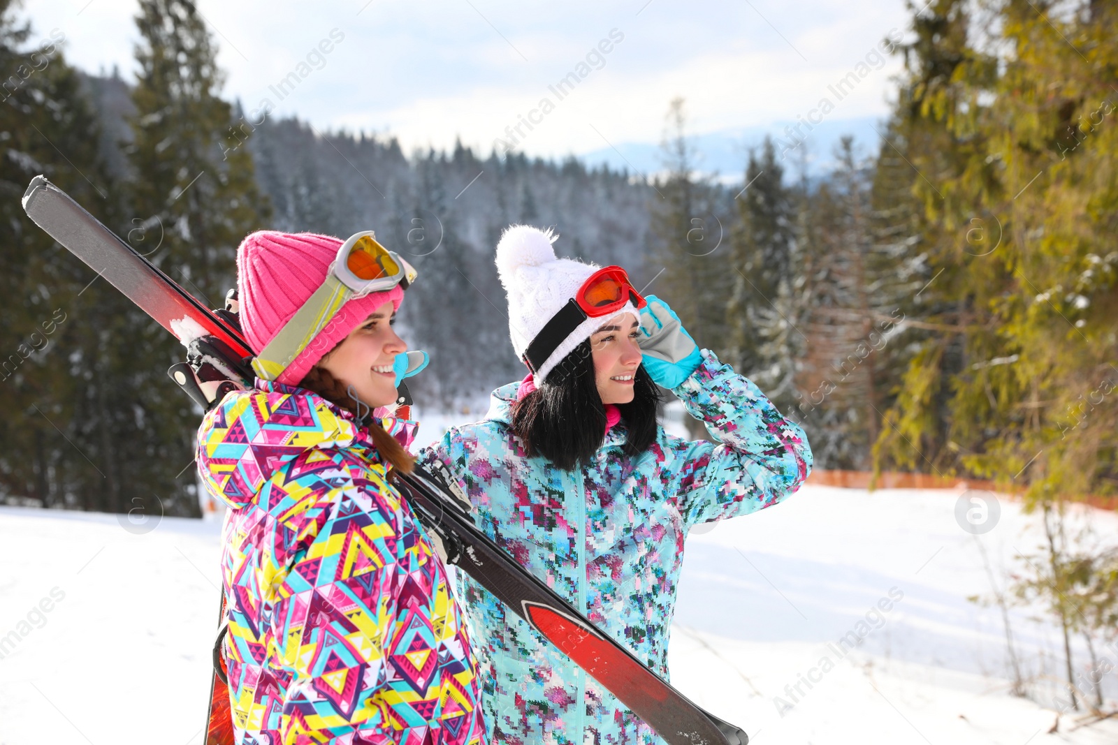 Photo of Friends resting on hill at mountain resort. Winter vacation