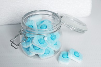 Photo of Jar with water softener tablets on white table, closeup