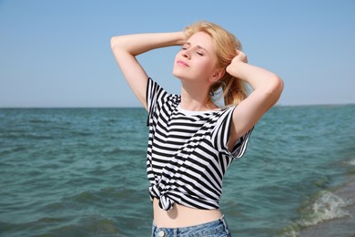 Photo of Beautiful young woman near sea on sunny day in summer