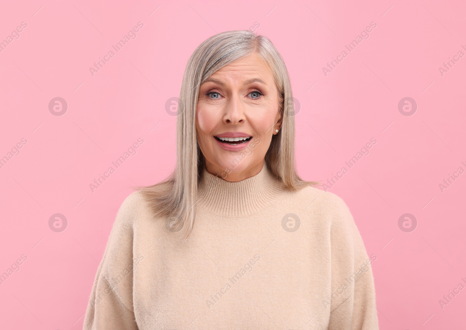 Photo of Portrait of emotional middle aged woman on pink background