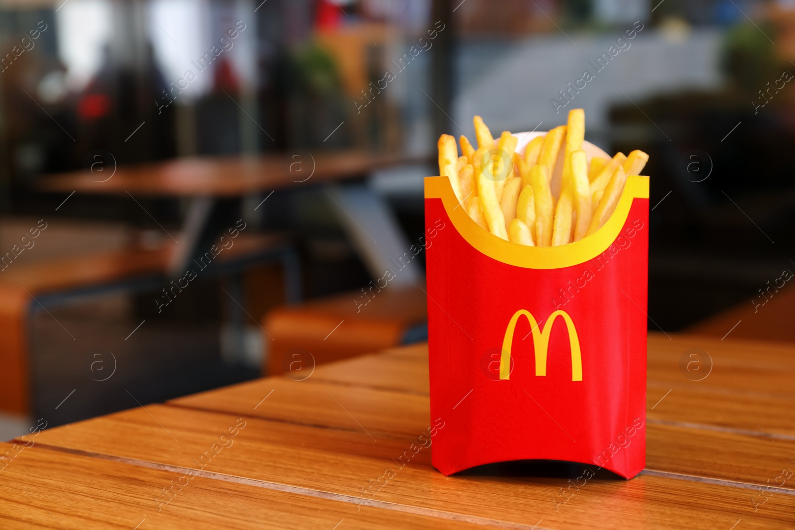 Photo of MYKOLAIV, UKRAINE - AUGUST 11, 2021: Big portion of McDonald's French fries on table in cafe. Space for text