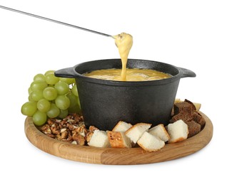 Dipping piece of bread into fondue pot with tasty melted cheese isolated on white