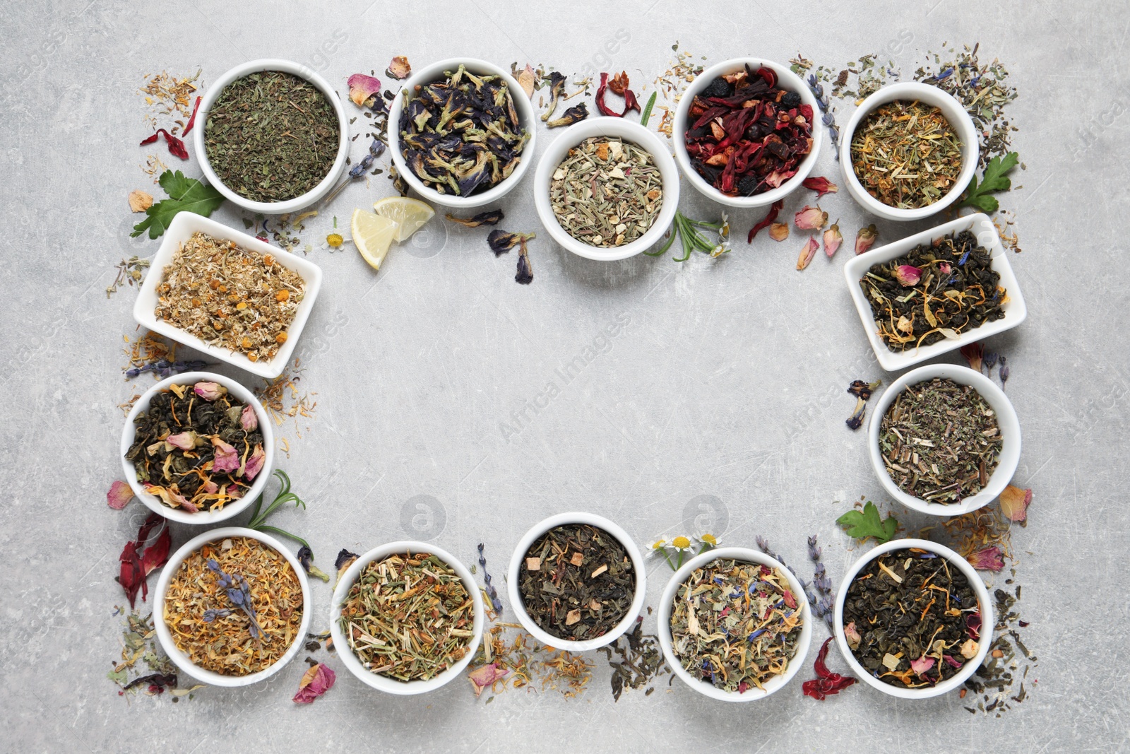 Photo of Frame of different dry teas on light grey table, flat lay. Space for text