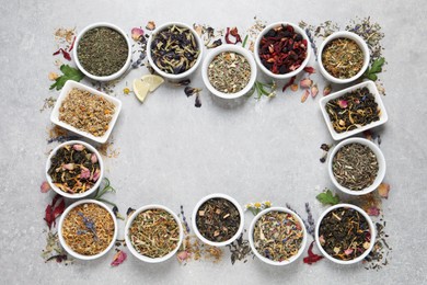 Frame of different dry teas on light grey table, flat lay. Space for text