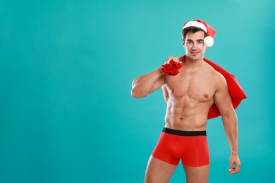 Sexy shirtless Santa Claus on blue background, space for text