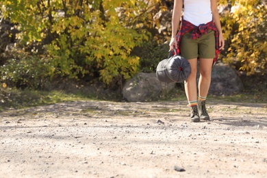 Female camper with sleeping bag outdoors, closeup. Space for text