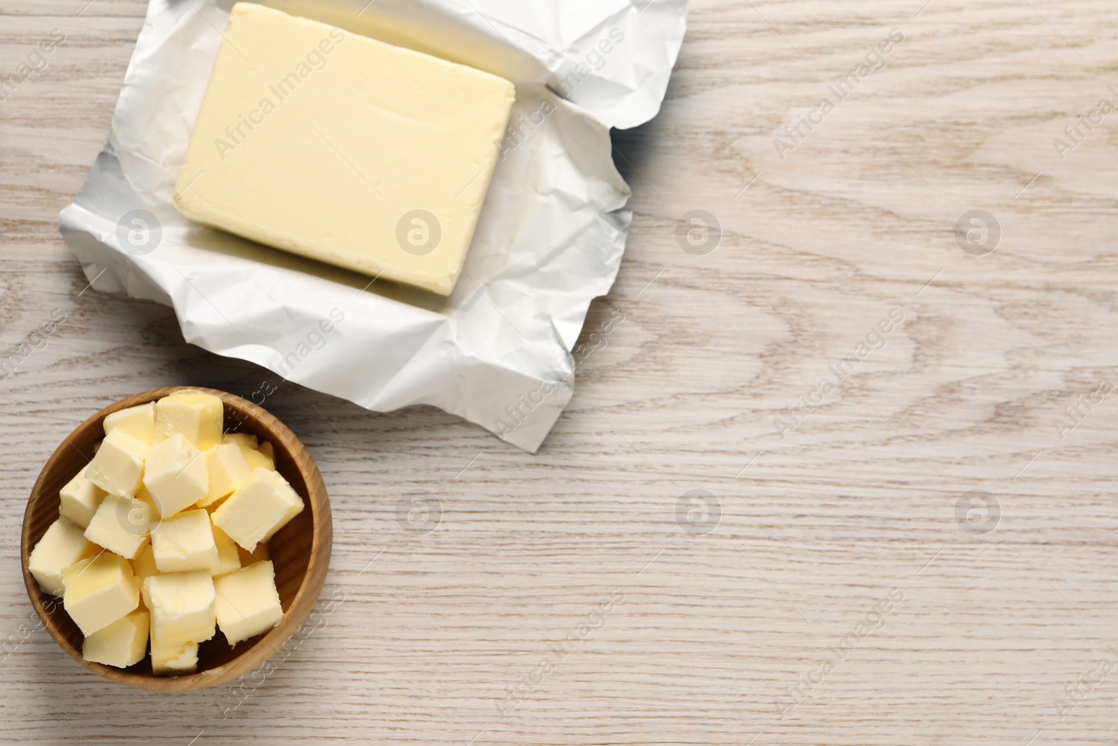 Photo of Tasty butter on light wooden table, flat lay. Space for text