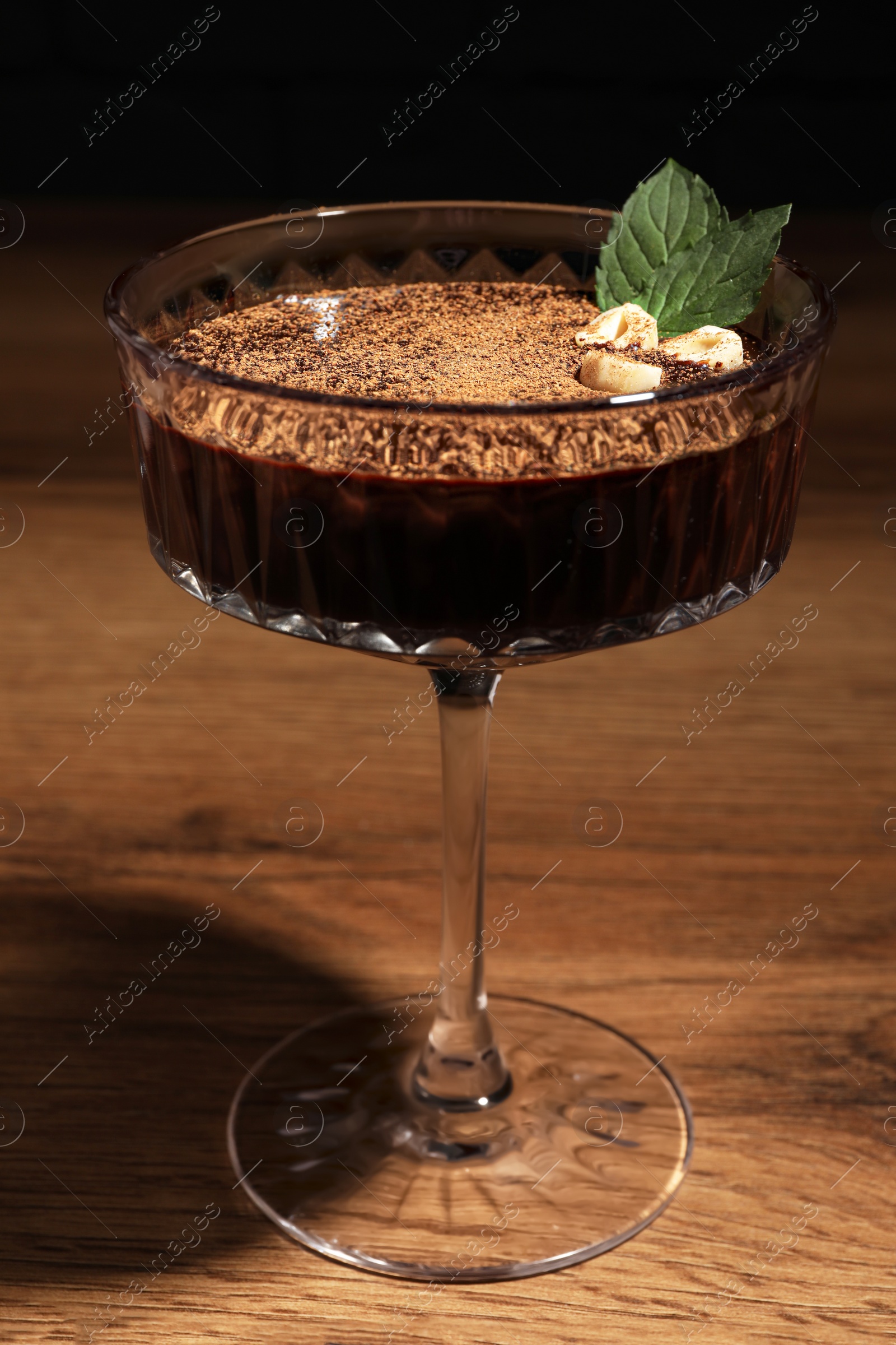 Photo of Dessert bowl of delicious hot chocolate with hazelnuts and fresh mint on wooden table