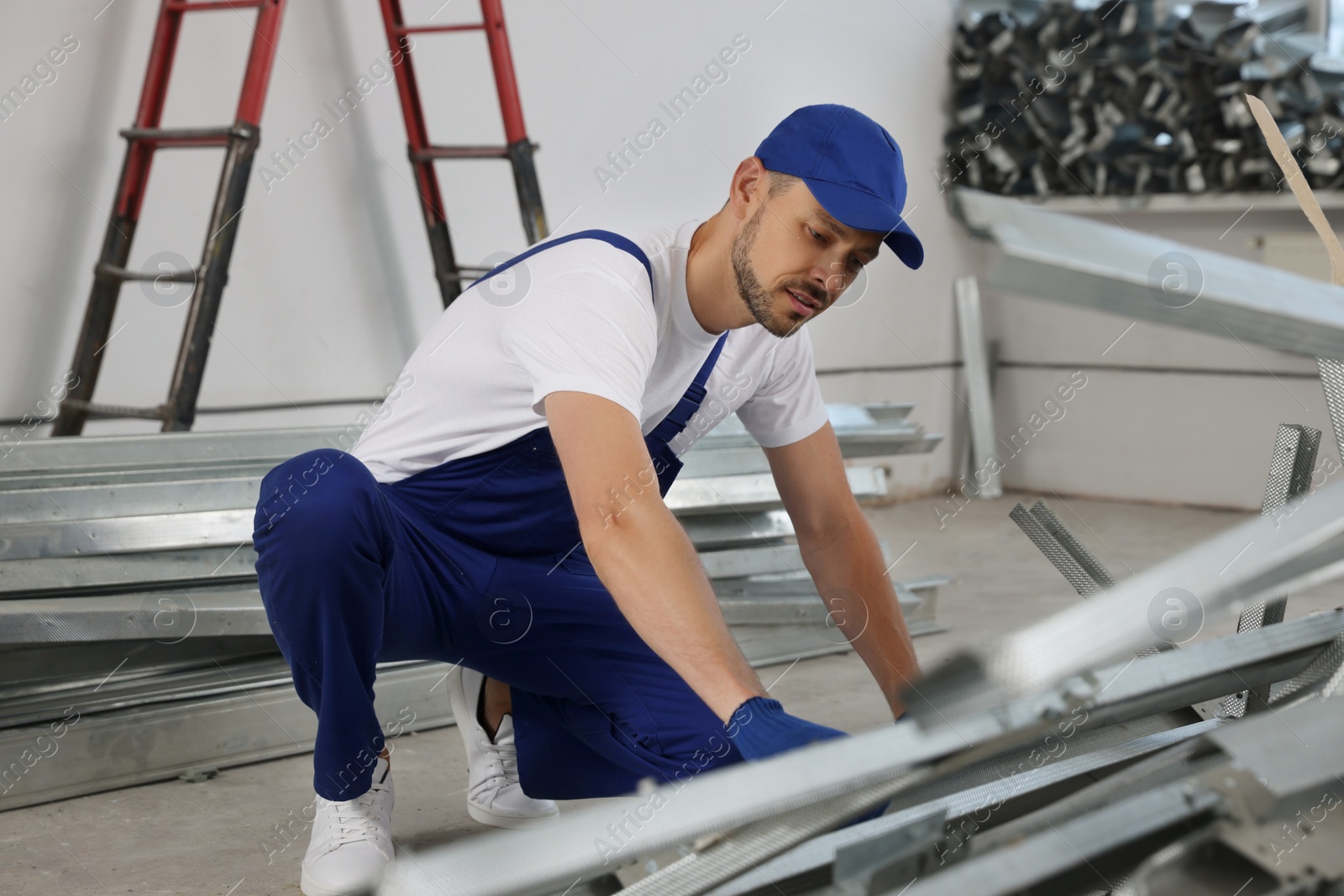 Photo of Construction worker with used building materials in room prepared for renovation