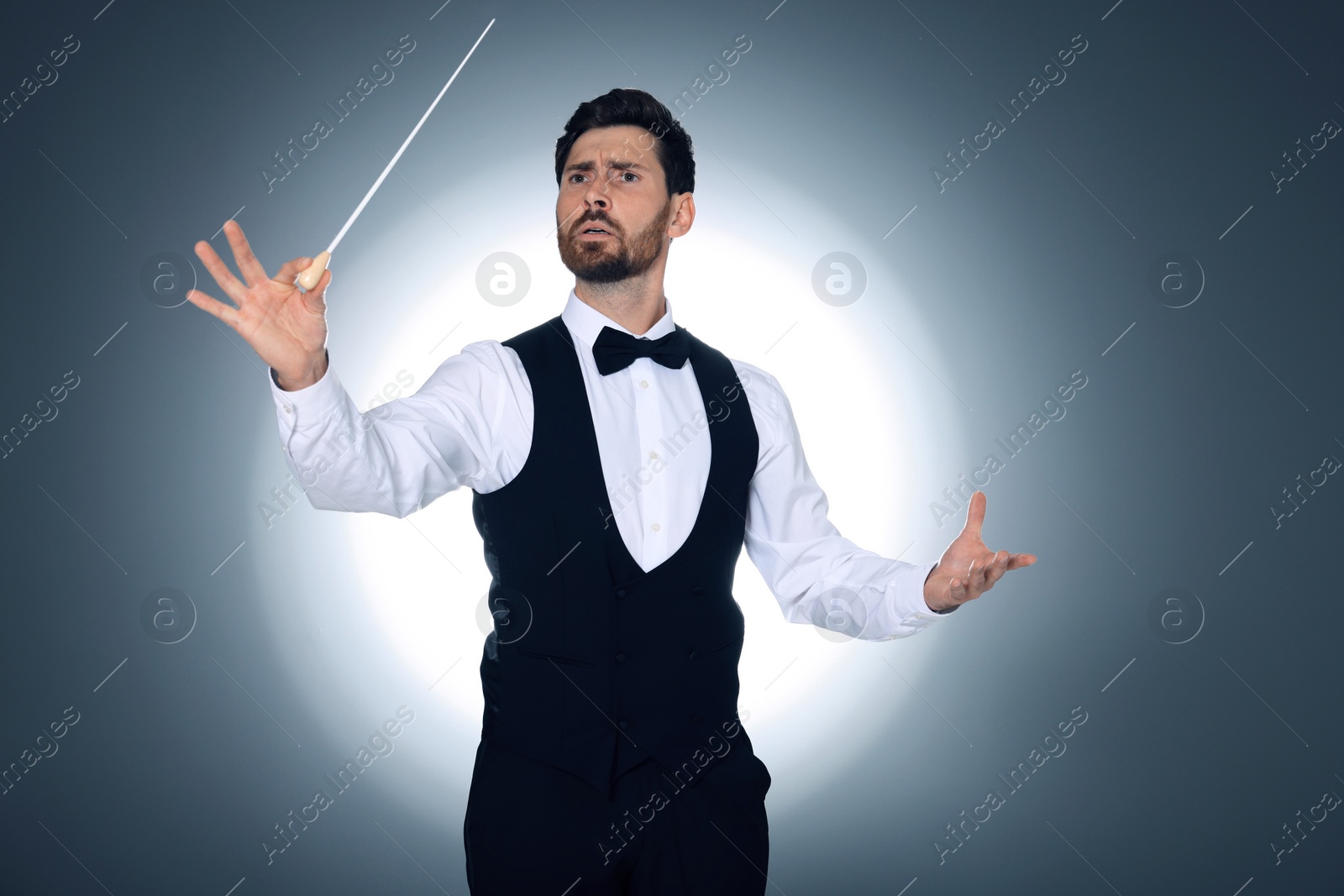 Photo of Professional conductor with baton on grey background