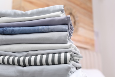 Photo of Stack of clean linens in bedroom, closeup
