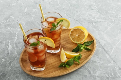 Photo of Glasses of delicious iced tea on marble table