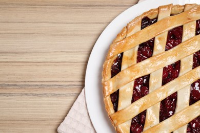 Photo of Delicious fresh cherry pie on wooden table, top view. Space for text