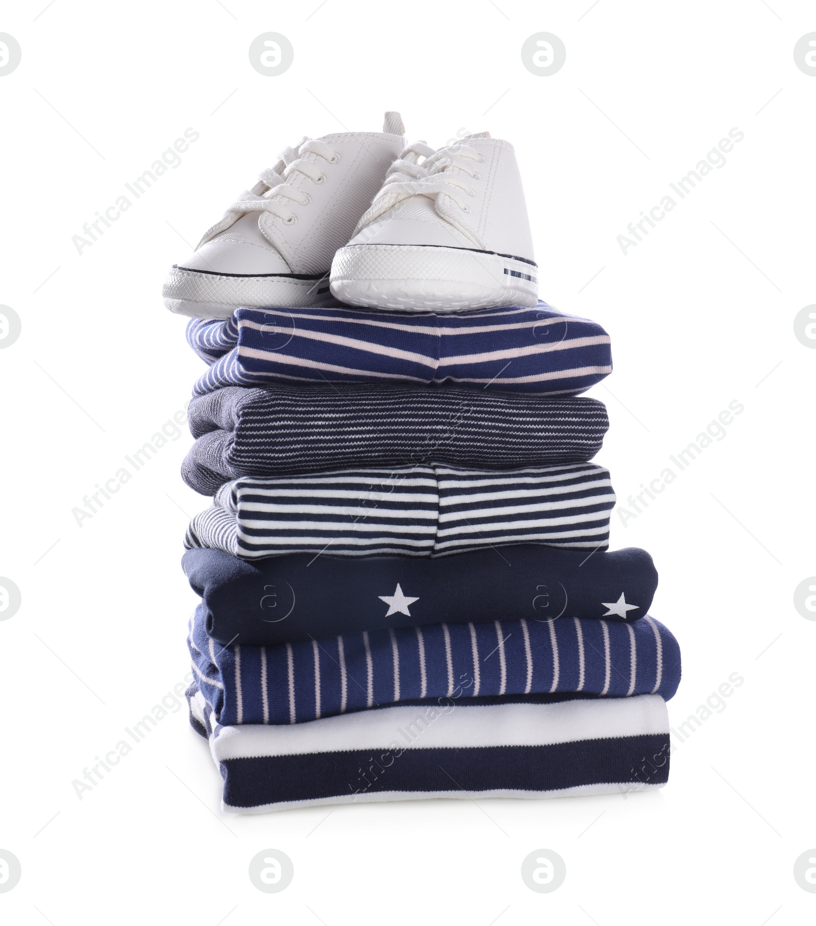 Photo of Stack of clean baby's clothes and small shoes on white background