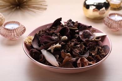 Photo of Aromatic potpourri of dried flowers in bowl on table