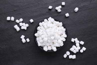 Photo of Bowl with delicious marshmallows on black background, flat lay