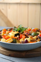 Photo of Delicious ratatouille in frying pan on grey table, closeup. Space for text