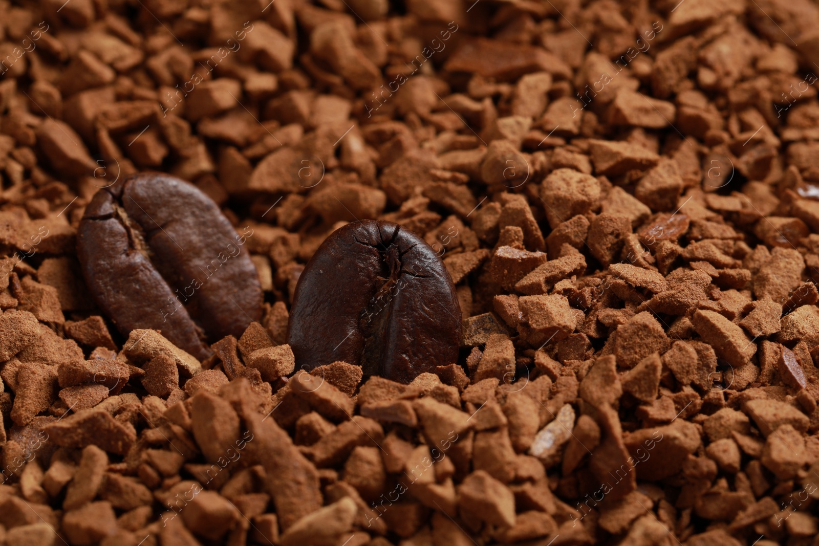 Photo of Roasted beans on instant coffee, closeup. Space for text