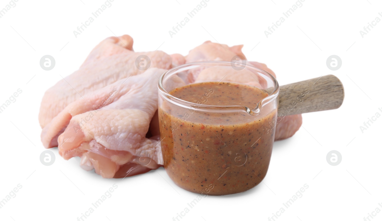 Photo of Fresh marinade and raw chicken wings isolated on white
