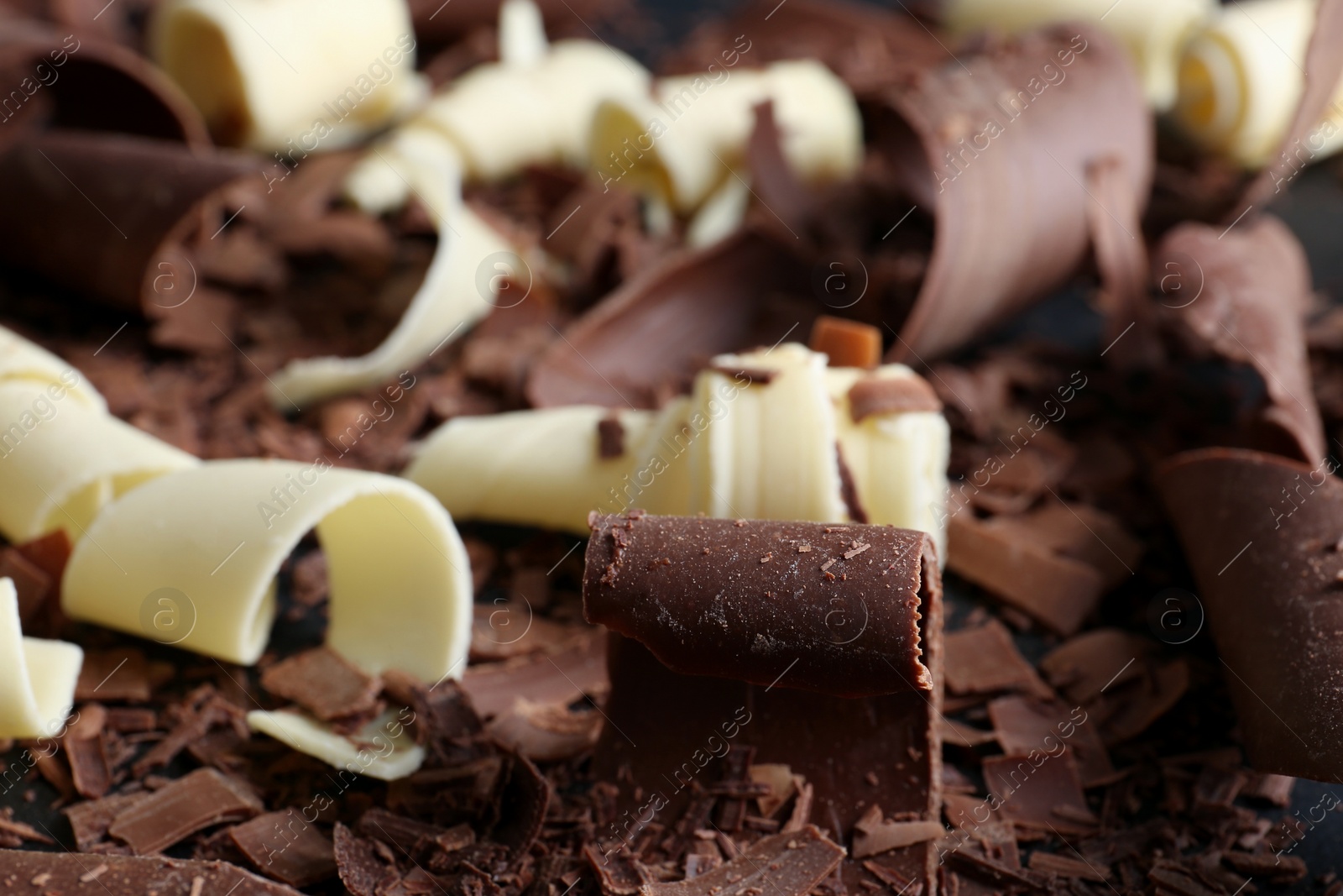 Photo of Yummy chocolate curls for decor as background, closeup