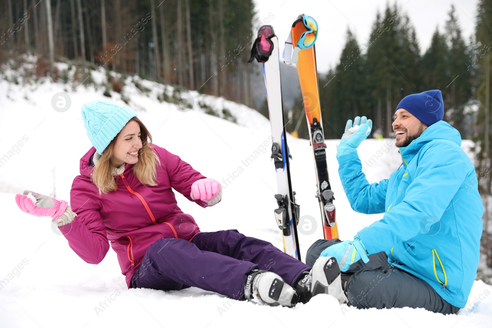 Photo of Couple of skiers playing with snow outdoors. Winter vacation