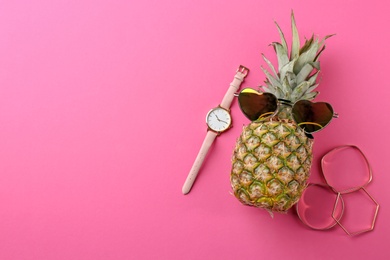 Photo of Funny pineapple with sunglasses, bracelets and watch on color background