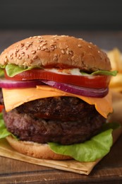 Photo of Tasty cheeseburger with patties on wooden board, closeup