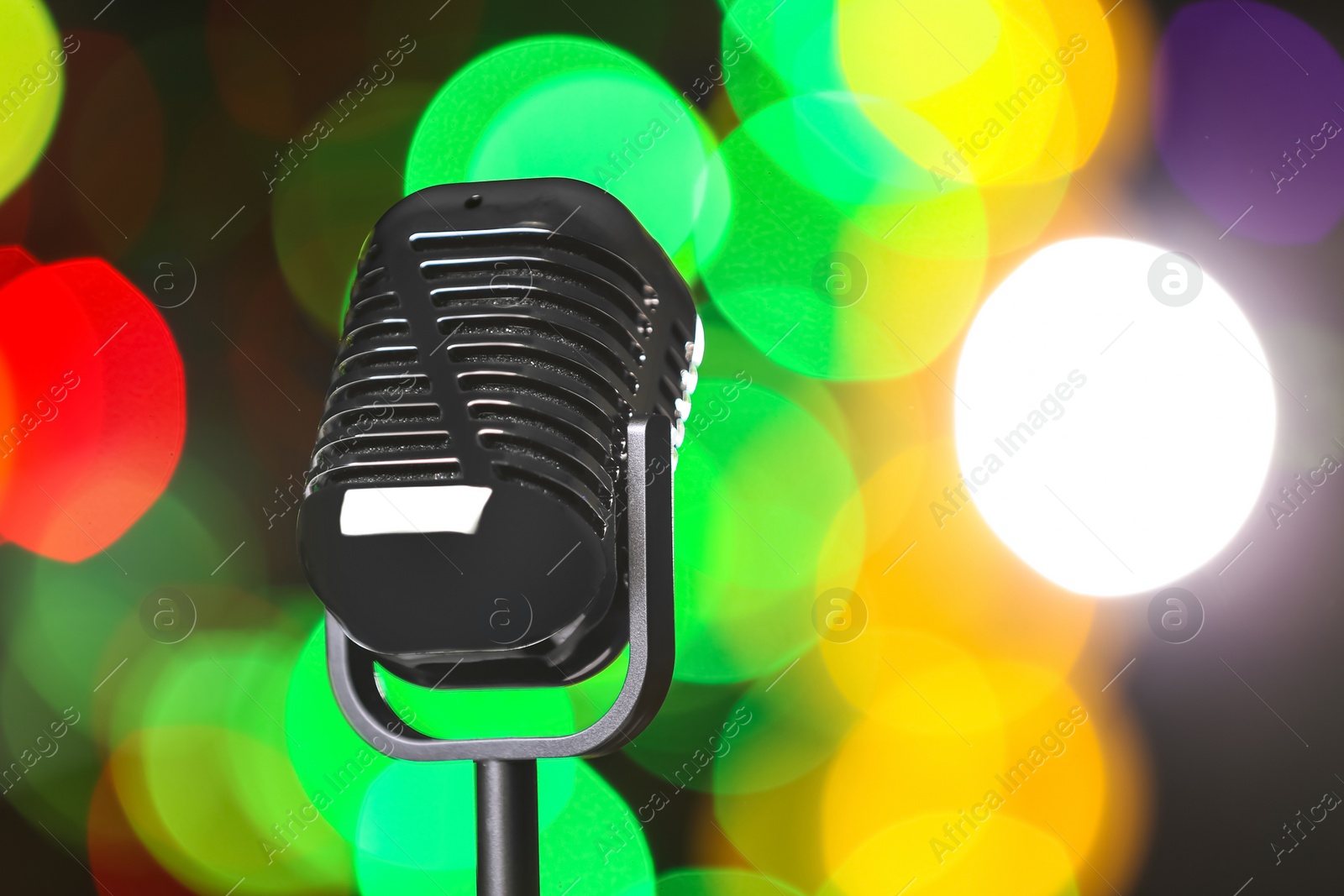 Photo of Retro microphone against festive lights, space for text. Musical equipment