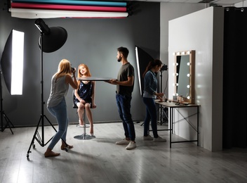 Photo of Photo studio with professional equipment and team of workers