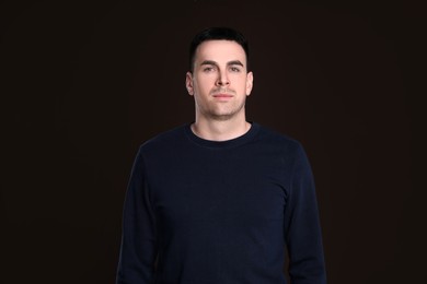 Portrait of handsome young man on dark background