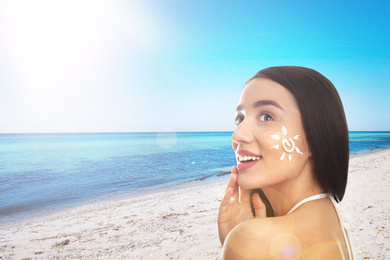 Image of Young woman with sun protection cream on her face at beach, space for text
