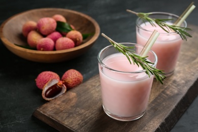 Photo of Delicious lychee cocktails with rosemary and fresh fruits on black table