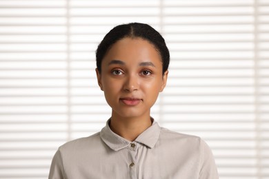 Portrait of beautiful woman looking at camera indoors