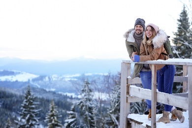 Couple spending winter vacation together in mountains. Space for text