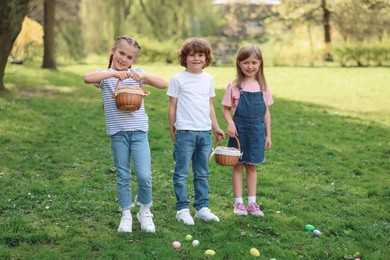 Easter celebration. Cute little children with wicker baskets and painted eggs outdoors