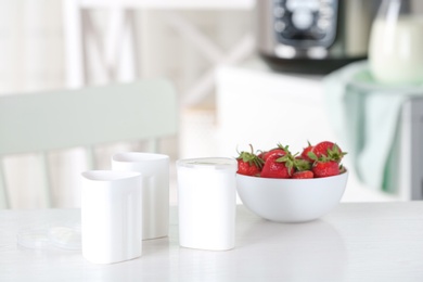 Cups for homemade yogurt and fresh strawberry on table in kitchen. Recipe for multi cooker