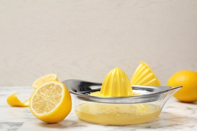 Photo of Composition with lemon squeezer and fresh fruit on table