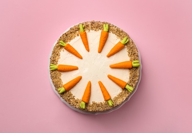 Dish with tasty carrot cake on pink background, top view