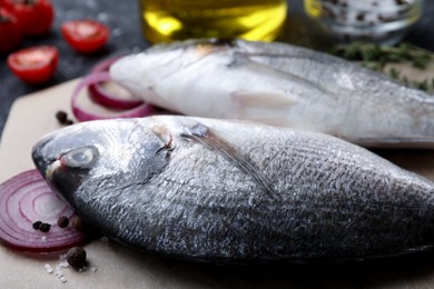 Fresh dorado fish and ingredients on wooden table, closeup