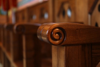 Photo of Empty wooden bench in church, closeup view