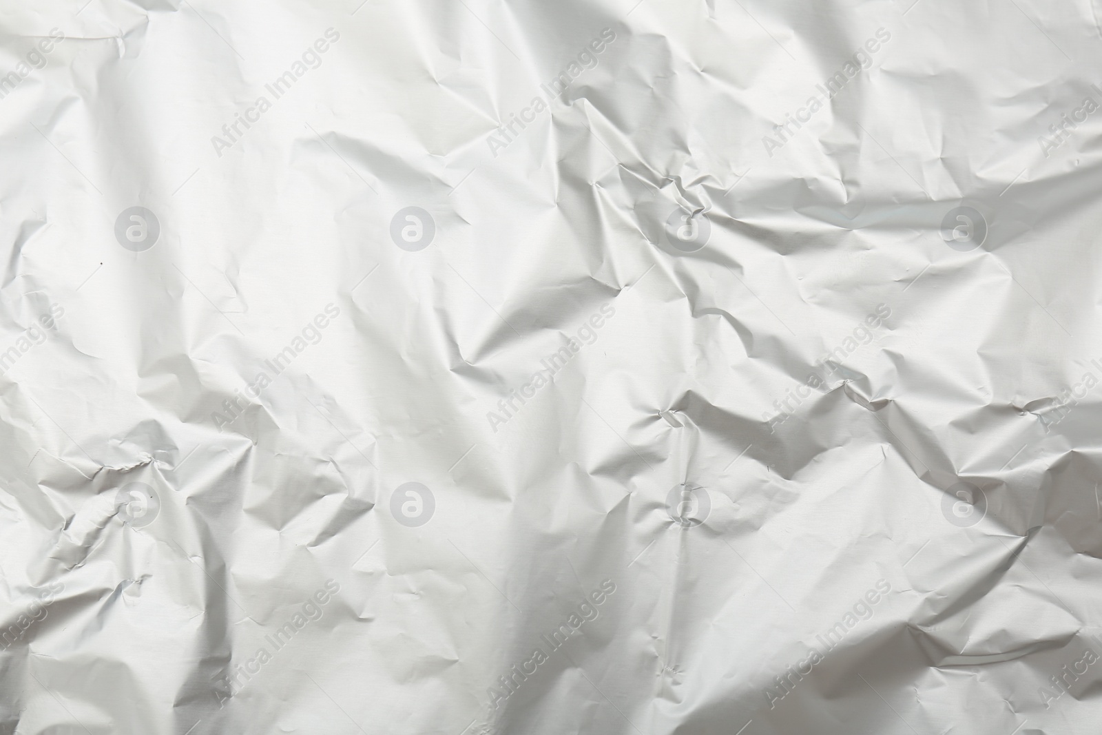 Photo of Crumpled silver foil as background, top view