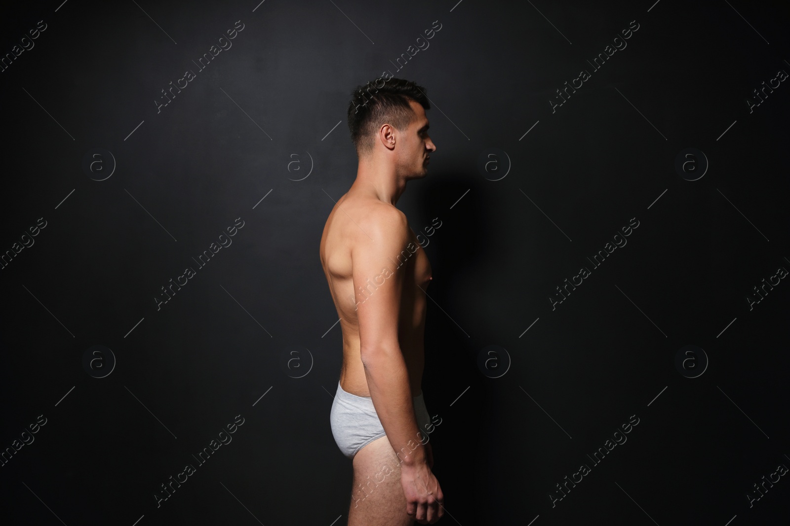 Photo of Handsome man wearing underwear on black background