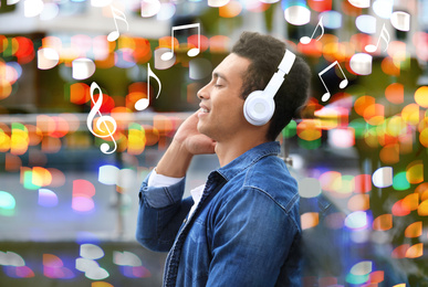 Image of Young African-American man listening to music outdoors. Bright notes illustration