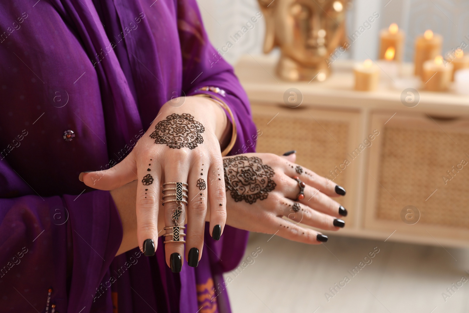 Photo of Woman with henna tattoos on hands indoors, closeup. Traditional mehndi ornament