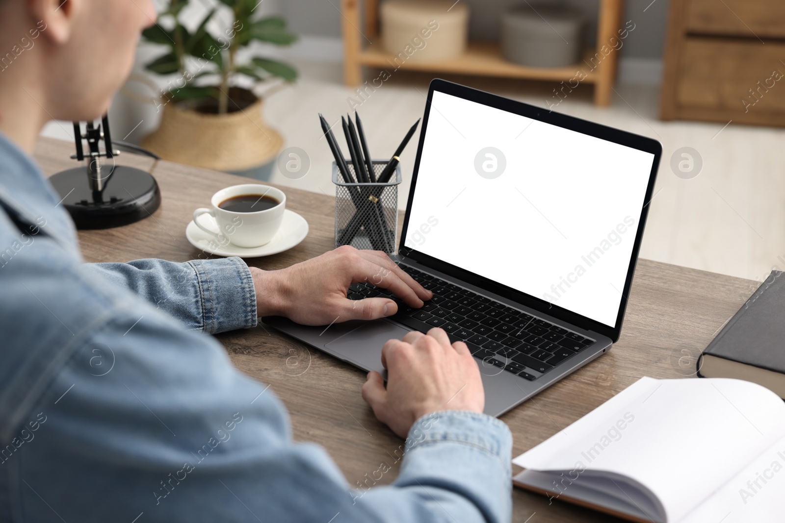 Photo of E-learning. Man using laptop during online lesson at table indoors, closeup