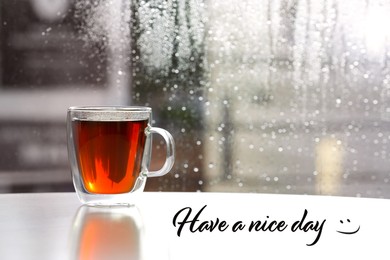 Image of Cup of fresh hot tea on windowsill and text Have a nice day
